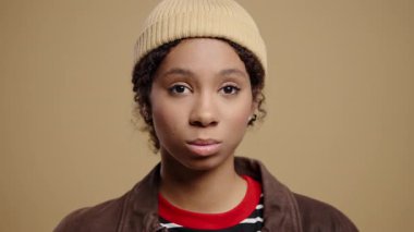 Kafa işareti olmadan onaylamadığı ciddi bir çift ırklı genç kadın, onaylamayarak başını sallıyor. Reddetmek, reddetmek, anlaşmazlık bej arka planda güzel bir bayanın portresi. Yüksek kalite 4k görüntü