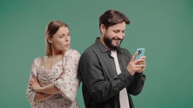 Şüpheli kadın, akıllı telefonlu erkek arkadaş sohbetlerini gözetliyor. Kıskançlık, merak, güvensizlik. Yeşil stüdyo geçmişi. Sırlar konsepti, gizli hayat. Yüksek kalite 4k