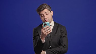 Sıkıcı Kayıtsız İşadamı Kaydırma Ağı, Cep telefonu, İnternet Bağımlılığı. Aletli üzgün bir adam, istediğini bulamıyor. Yüksek kalite 4k görüntü