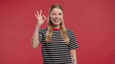 Kadın modeli onaylamak için gülümseyerek el hareketi yapıyor. Doğrulama, başarı, memnuniyet, olumlu tepkiler.