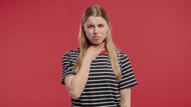 Genç ve güzel bir kadının yarası var. Kırmızı Stüdyoda Boğazı Şişmiş Hasta Kadın. Anjin. Genç kız acı hissediyor, acı çekiyor. Mevsimsel grip, soğuk algınlığı. Yüksek kalite 4k