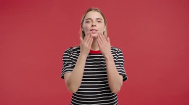 Çekici kadın manken yumuşak, şefkatli bir jest, şefkat ve açıklıkla öpücük yolluyor. Romantik, dostane, flörtöz, duygusal yaşam tarzı temaları 