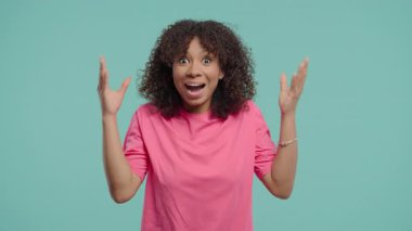 Pembe elbiseli Afrikalı bir kadının el hareketleriyle tepki verdiği bir fotoğraf. Başlangıç videoları, fikir üretimi, reklamcılık, sosyal medya içeriği