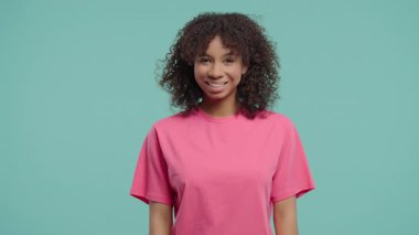 Şık liseli kız, doğal gerçek güzellik. Genç bayan kameraya gülümseyerek bakıyor. Sağlıklı cilt ve dişler. Afrikalı kıvırcık saçlı melez bir kadın, Z jenerasyonunda otantik bir kadın model..
