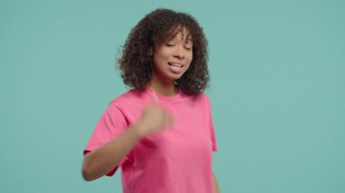 Güzel, genç, Afrikalı bir kadın ona katılmasını istiyor. El sıkışma jesti ile işaret ediyor. Güzel bayan arıyor - Hey sen, buraya gel. Oyuncu, davetkar. Mavi stüdyo arka planı