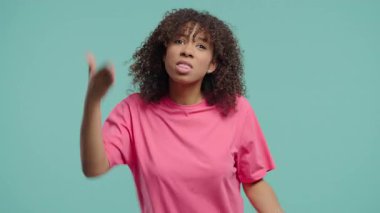 Stres ve öfke içindeki Afrikalı Kadın saldırganlıkla, bağırmakla ve mavi kameraya bakmakla tehdit ediyor. Öfkeli Amerikalı kadın. Çatışma, tartışma, stres, duygusal patlamalar. Yüksek kalite 4k görüntü