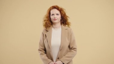 Serious businesswoman disapproving with no head sign, nods head disapprovingly. Denying, Rejecting, Disagree, Portrait of pretty lady on beige background. High quality 4k footage