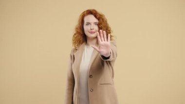 Female model - woman lifts her hand in visible stop motion, sending strong boundary signal. Personal space, safety, refusal, behavioral control themes High quality 4k footage