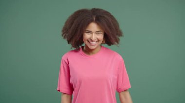 Gorgeous african american woman showing yes signal, nods head, approve. Positive smiling girl, body language. Correct perfect choice, great deal. green studio background.