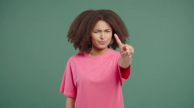 Uninterested stylish young african american teenager disapproving with stop finger sign. Dont play with me, enough. Portrait of lady on green background. High quality 4k