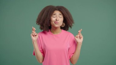 African american pretty teenager girl praying, begs to apologize her, she is guilty. Green background. Hopeful prayer woman asking someone satisfy her desires, help with. High quality 4k