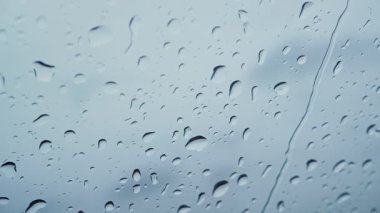 Camına düşen su damlaları görünümünü kapatın. Camda çalışan aşağı yağmur. Yağmur mevsimi sonbahar. Yağmur damlaları yere cihazı, gökyüzü gri. Büyük özel efekt ve hareketli grafikler.