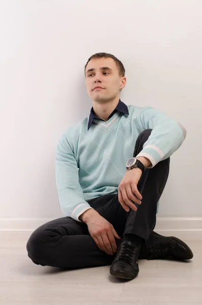 Portrait Young Man Sitting Floor Wall Blue Sweater Black Shirt — Stock Photo, Image