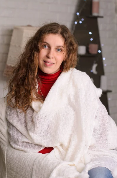 Atraktivní Žena Dlouhými Vlnitými Vlasy Sedí Zabalená Bílém Pleteném Šátku — Stock fotografie