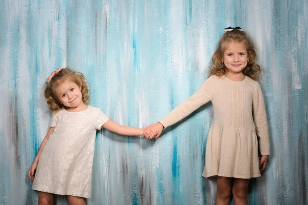 Two Beautiful Smiling Girls Sisters Light Dresses Stand Blue Wall — Stock Photo, Image