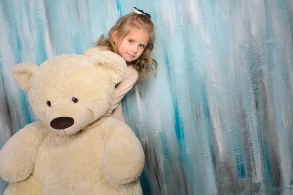 Krásná Dívka Vykoukne Zpoza Malého Medvídka Kterého Objímá Stojí Modré — Stock fotografie