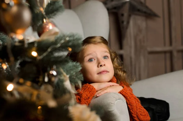 빨간색 스웨터를 소녀는 크리스마스 의자에 그녀의 얼굴을 그녀의 — 스톡 사진