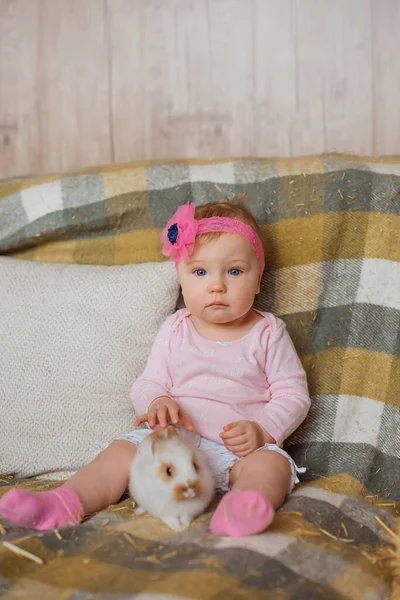 若い女の子はピクニック毛布の上に座っています 彼女の繊細な手は優しく純白のウサギの美しい毛皮を愛撫 — ストック写真