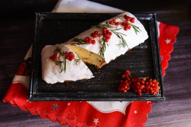 Keki viburum ve beyaz kremayla kes, koyu arkaplandaki tahta tepside.