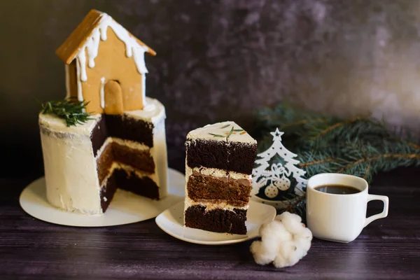 巧克力蛋糕 装饰着姜饼屋 旁边有一块切好的面包 放在茶托上 还有一杯咖啡 — 图库照片