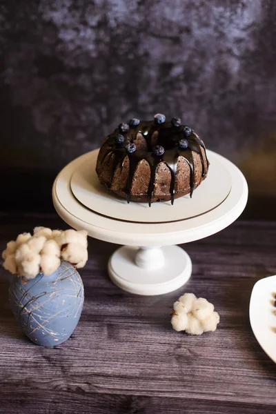 Csokoládé Cupcake Cukormázzal Egy Fehér Tányéron Egy Állvány Egy Váza — Stock Fotó