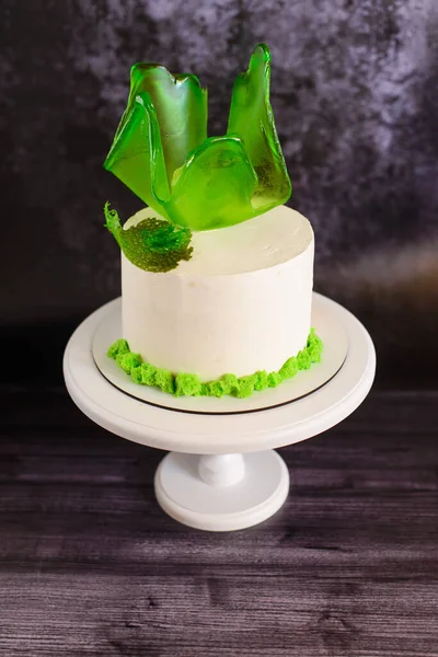 Białe Ciasto Stoisku Ozdobione Zielonymi Cukierkami Ciemnym Tle — Zdjęcie stockowe