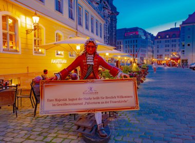 Şehrin 11.05.2022 tarihsel bölümü ve restoranın yakınında bir reklam heykeli. Geceleri turistlerin ve restoranların olduğu şehir caddesi. Dresden, Almanya