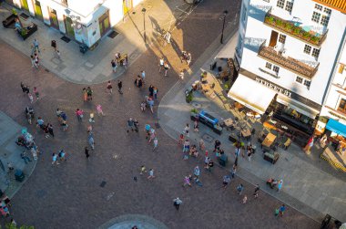 04-07-2022: Yazın Torun Eski Kasabası 'nın tarihi kaldırım taşlı caddelerinde yürüyen insanların görüntüsü, Ratusz Saat Kulesi' nin yüksek peronundan çekildi