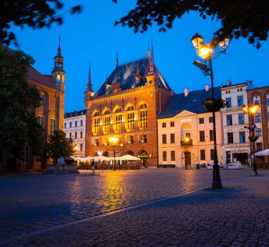 04-07-2022: Torun 'da Artus Court satışta. Alacakaranlıkta şehir simgesi. Polonya