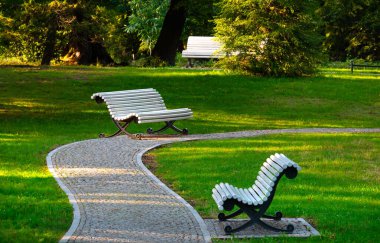 Parktaki kaldırımda beyaz banklar