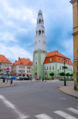 2024-05-31; Avrupa 'da Gryfow Slaski, Polonya' da bir saat kulesi ve renkli binaların yer aldığı tarihi kent meydanı.