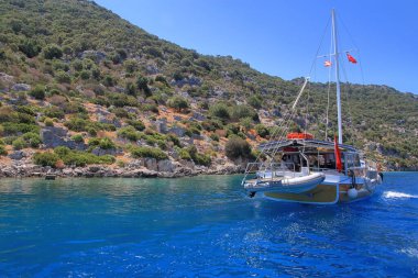 Fotoğraf Türkiye 'de Kekova adası yakınlarında çekildi. Resim, Akdeniz 'deki adanın pitoresk kıyıları boyunca bir yat gezisini gösteriyor..