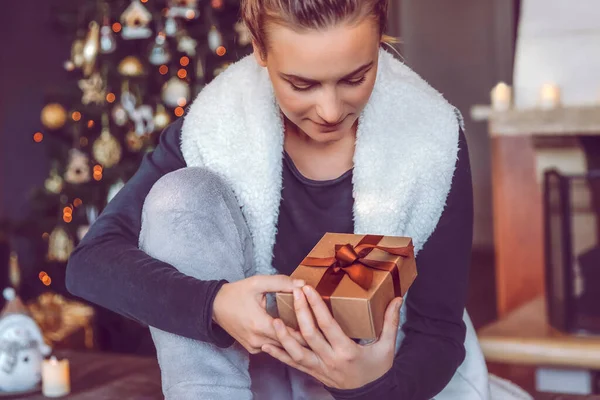 一个漂亮女人圣诞节收到礼品盒的肖像 快乐的女孩得到了一个过冬的礼物 在家中庆祝圣诞及新年 — 图库照片