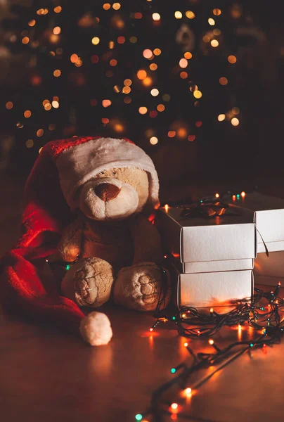 可爱的熊穿着红色节日的圣诞老人帽 在美丽而明亮的圣诞树下 戴着银质礼盒 新年快乐 — 图库照片