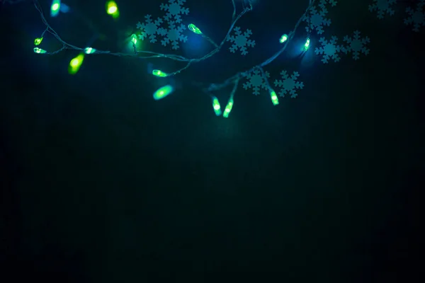 Glänzend Grüne Weihnachtsbaumgirlanden Über Dunklem Hintergrund Schneeflocken Konfetti Dekoration Foto — Stockfoto