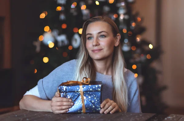 一个漂亮的女人的肖像 她在家里带着节日礼品盒 而不是装饰圣诞树的背景 寒假快乐 — 图库照片