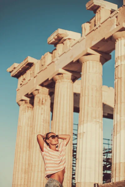 在雅典参观华丽旅游胜地的漂亮女人 阳光灿烂的日子里 帕台农神庙令人惊奇的巨大柱子 喜欢到欧洲旅游的有趣游客 — 图库照片