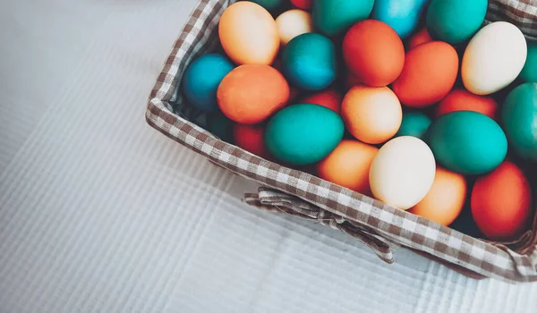 カラフルなイースターエッグのバスケットの写真を閉じます 卵を着色する 白いテーブルの上の食品の境界線 偉大なキリスト教の休日の伝統的なシンボル — ストック写真