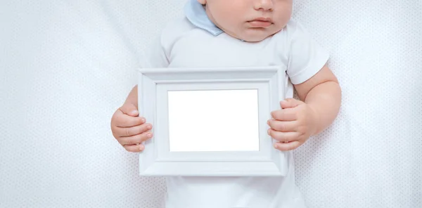 一个可爱的小男孩躺在床上 手牵着手 里面拿着白纸的照片 复制空间 概念性照片 — 图库照片