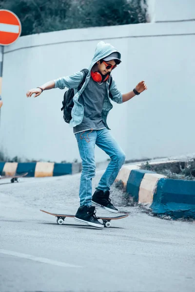 快乐活泼的少年骑在滑板上 在街上听音乐 极端的生活方式现代青少年文化 — 图库照片