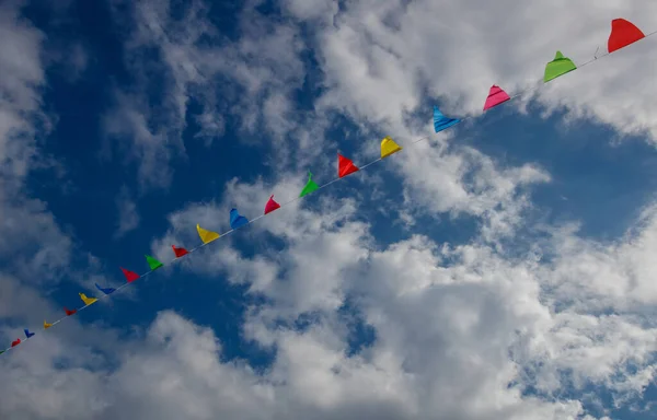 幸せな誕生日パーティーの概念的な写真を屋外で ふわふわした雲の背景には 空にカラフルな三角形の旗がたくさん お祝いの日 — ストック写真