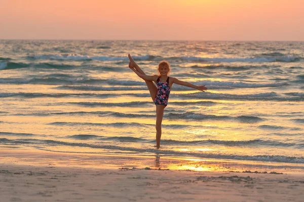 Cute Teen Girl Robi Gimnastykę Plaży Nad Zachodem Słońca Tle — Zdjęcie stockowe
