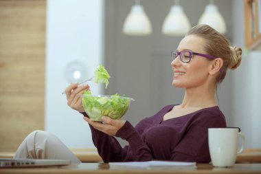Yemek zamanı. Neşeli bir kız güzel bir yeşil salatayla öğle yemeği yemeye karar verdi. Sağlıklı seçimler