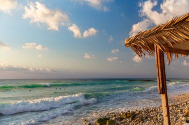 Okyanus kıyısı deniz manzarası güneşli mavi bir gökyüzü, kumsalda bir bungalov, büyüleyici güzel bir manzara. Temiz hava, deniz suyu ve güneş. Tatil için mükemmel bir kombinasyon..