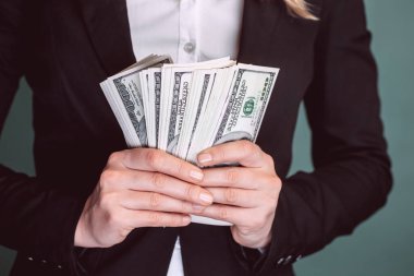 Bir sürü para. Bir iş kadınının elinde dolar var. Parayla ellerini kapat. İş adamları. Para yapma kavramı.