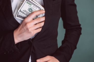 Kız cebinde bir yığın para saklıyor. İş kadınlarının elinde dolar var. Parayla ellerini kapat. İş adamları. Para kazanma kavramı