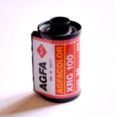 NAPLES, ITALY, 5 Ocak 2024: Beyaz arkaplanda bir rulo AGFA XRG 100, 35 mm analog kamera filmi.