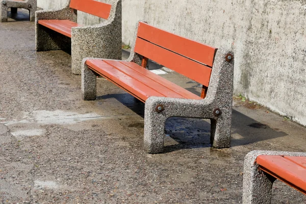 Bulvarın yanındaki beton duvar boyunca sıralanmış sıralı sandalyeler. Bu banklar beton ve vukuattan yapılmış.