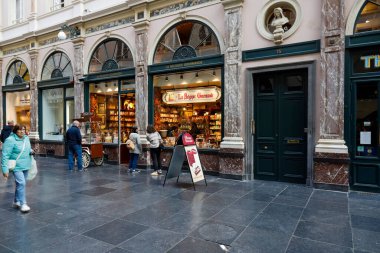 Brussels, Belgium - September 18, 2022: The shop window encourages chocolate gourmets to buy in this store located inside the Royal Galleries of Saint Huber clipart