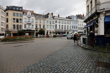 Brussels, Belgium - September 17, 2022: The buildings in the city are visible along the street and there is a small roundabout nearby. There are a few people on the sidewalk but traffic is rather light